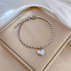 pulsera plateada de pelotitas con dige de corazón al centro blanco
